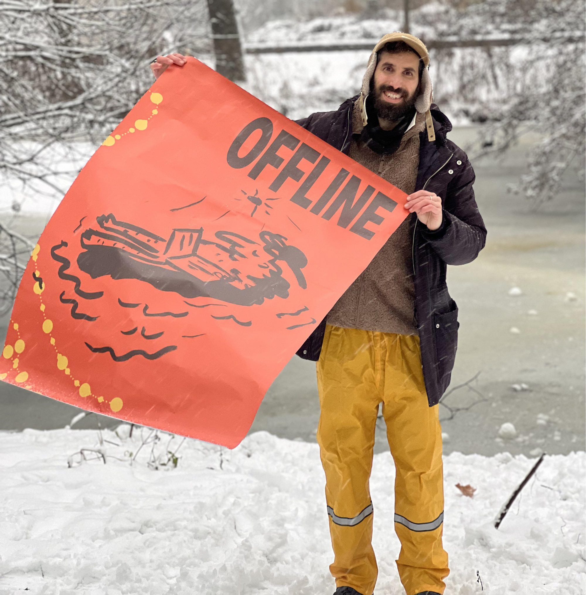 Man in the winter snow holding poster